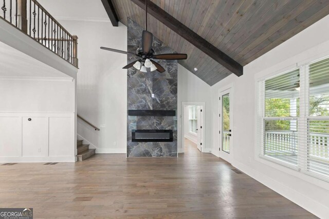 unfurnished living room with beam ceiling, a premium fireplace, high vaulted ceiling, and wood-type flooring