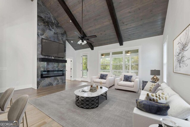 living room featuring ceiling fan, wooden ceiling, a high end fireplace, high vaulted ceiling, and wood-type flooring