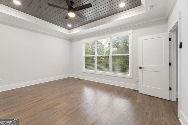 unfurnished room featuring ceiling fan, wooden ceiling, dark hardwood / wood-style flooring, crown molding, and a tray ceiling