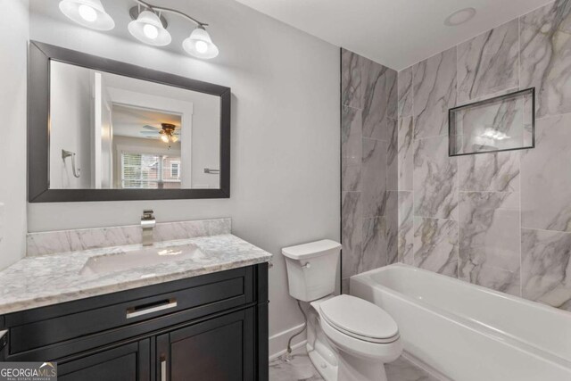 full bathroom with tiled shower / bath, ceiling fan, vanity, and toilet