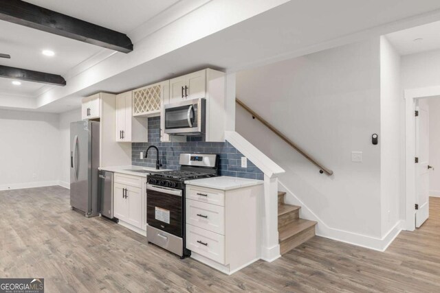 kitchen featuring white cabinets, stainless steel appliances, light hardwood / wood-style flooring, and sink