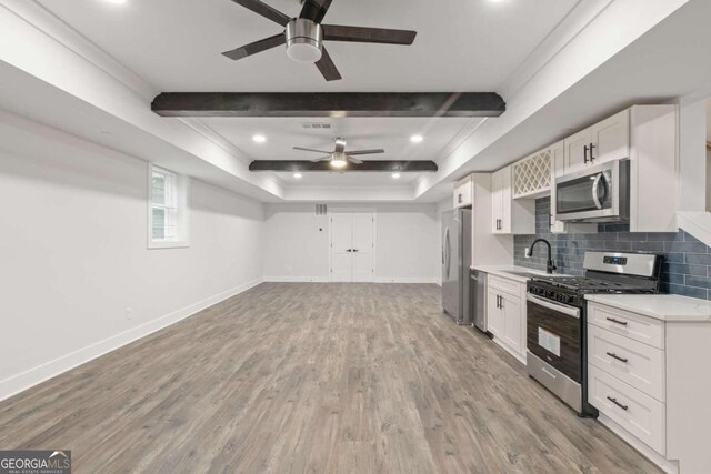 kitchen with light wood-type flooring, tasteful backsplash, stainless steel appliances, sink, and white cabinets