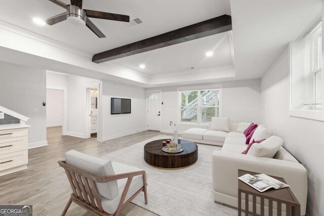 living room featuring beam ceiling, light hardwood / wood-style floors, a raised ceiling, and ceiling fan