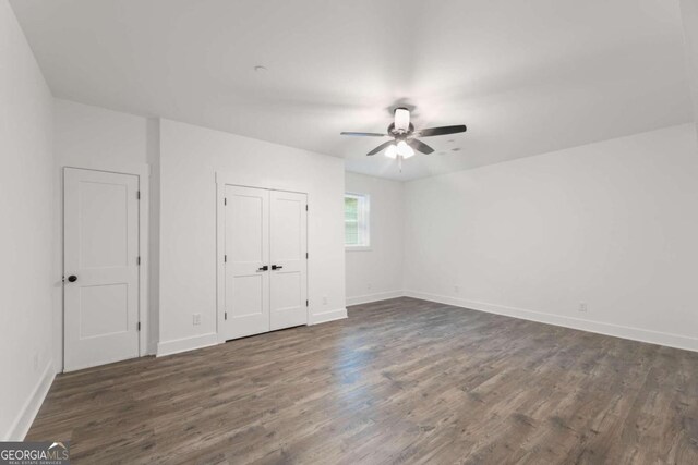 unfurnished bedroom featuring ceiling fan and dark hardwood / wood-style floors