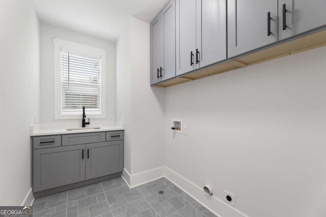 laundry room with hookup for an electric dryer, cabinets, sink, and hookup for a washing machine