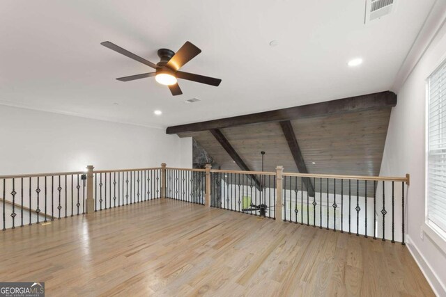 additional living space with ceiling fan, lofted ceiling with beams, and light wood-type flooring