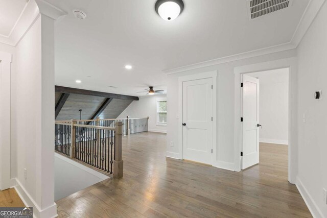 corridor with wood-type flooring and crown molding