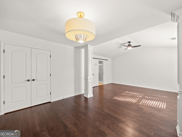 unfurnished living room featuring dark hardwood / wood-style floors, ceiling fan, ornate columns, and vaulted ceiling