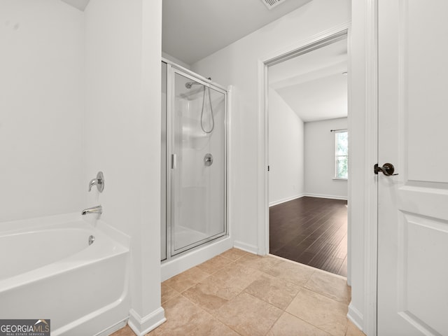 bathroom with shower with separate bathtub and hardwood / wood-style flooring