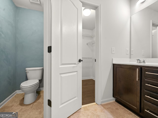 bathroom featuring tile patterned flooring, vanity, and toilet