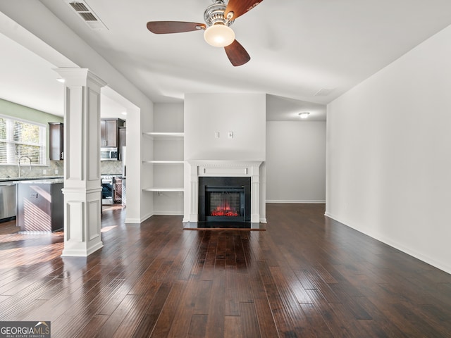 unfurnished living room featuring ceiling fan, sink, and dark wood-type flooring