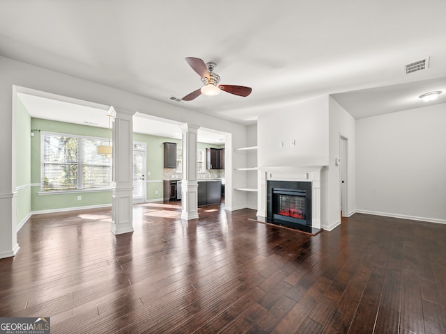 unfurnished living room with built in shelves, ceiling fan, and dark hardwood / wood-style flooring