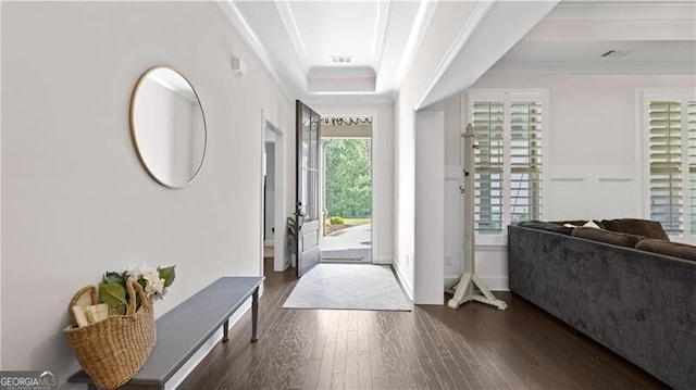 foyer entrance featuring a raised ceiling, crown molding, and dark hardwood / wood-style flooring