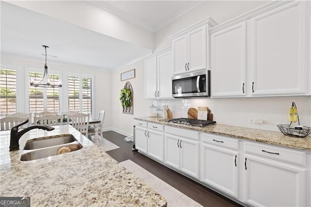 kitchen with white cabinets, sink, hanging light fixtures, dark hardwood / wood-style floors, and stainless steel appliances