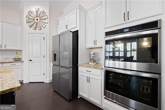 kitchen with light stone countertops, appliances with stainless steel finishes, dark hardwood / wood-style floors, and white cabinetry