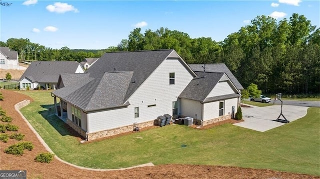 rear view of house with a lawn and central AC