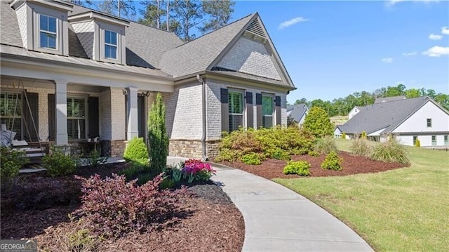 view of home's exterior with covered porch and a lawn