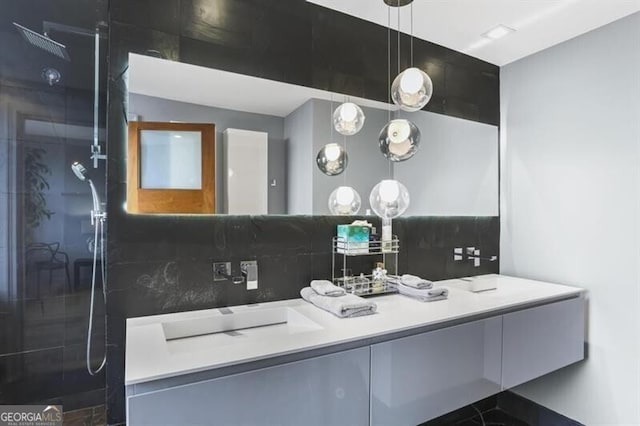 bathroom featuring decorative backsplash, vanity, and walk in shower