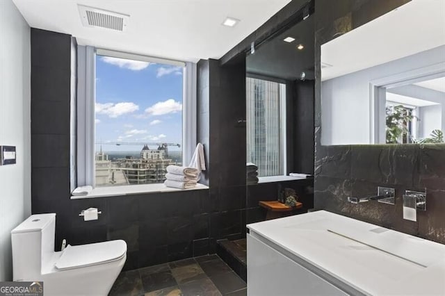 bathroom featuring decorative backsplash, a shower, toilet, and tile walls