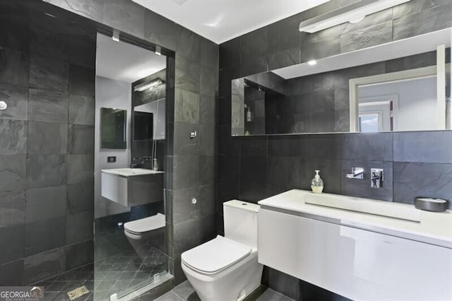 bathroom with vanity, decorative backsplash, toilet, tile walls, and a tile shower