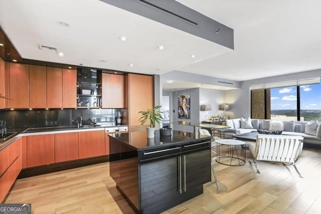 kitchen with light hardwood / wood-style floors, sink, and backsplash