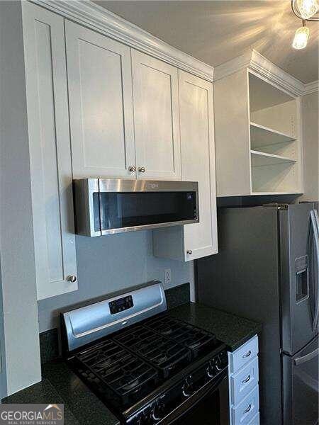 kitchen featuring crown molding, white cabinetry, and stainless steel appliances