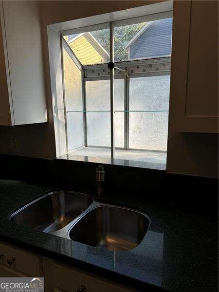 details with dark stone countertops and sink