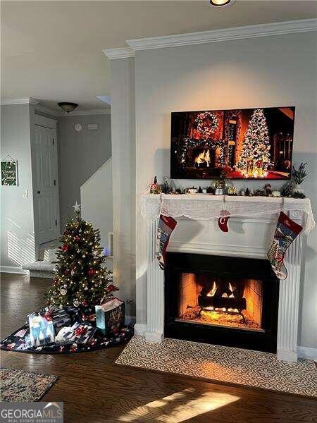 interior details with hardwood / wood-style flooring and crown molding