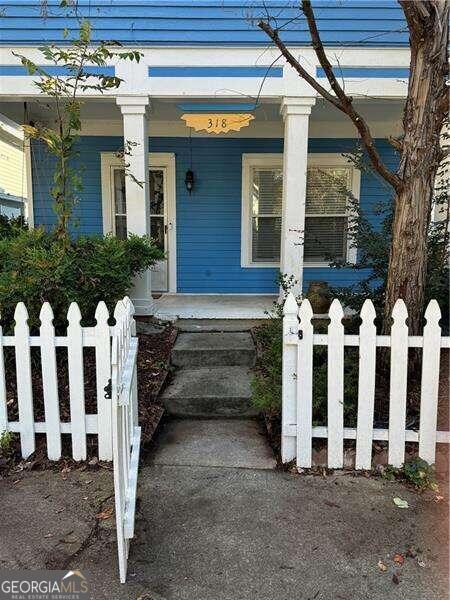 view of exterior entry featuring covered porch