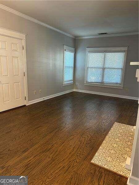 unfurnished room with dark hardwood / wood-style flooring and ornamental molding