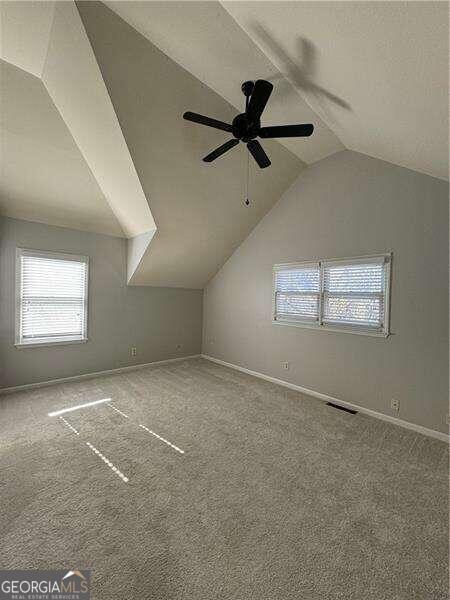 additional living space with ceiling fan, carpet floors, and vaulted ceiling