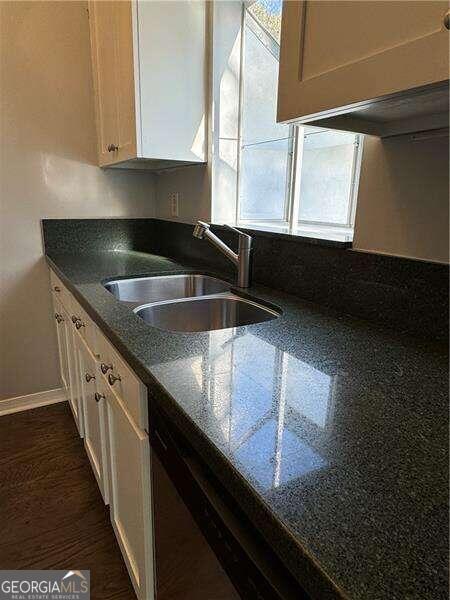 kitchen with dark hardwood / wood-style flooring, dishwasher, and sink