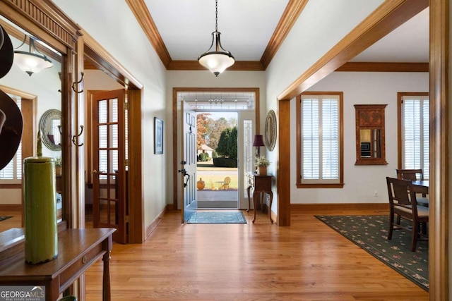 entryway with light hardwood / wood-style flooring and crown molding