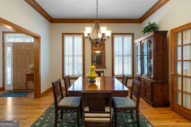 dining area with plenty of natural light, light hardwood / wood-style floors, and an inviting chandelier