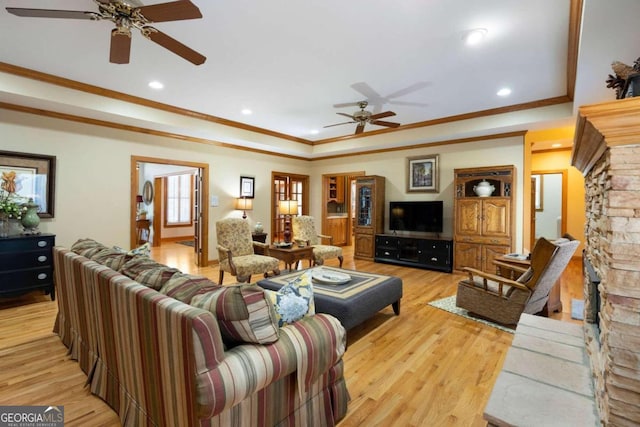 living room featuring light hardwood / wood-style floors, ceiling fan, and crown molding