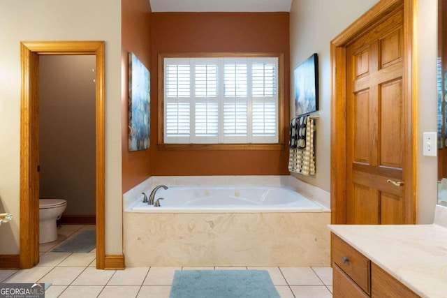 bathroom with tile patterned flooring, vanity, a relaxing tiled tub, and toilet