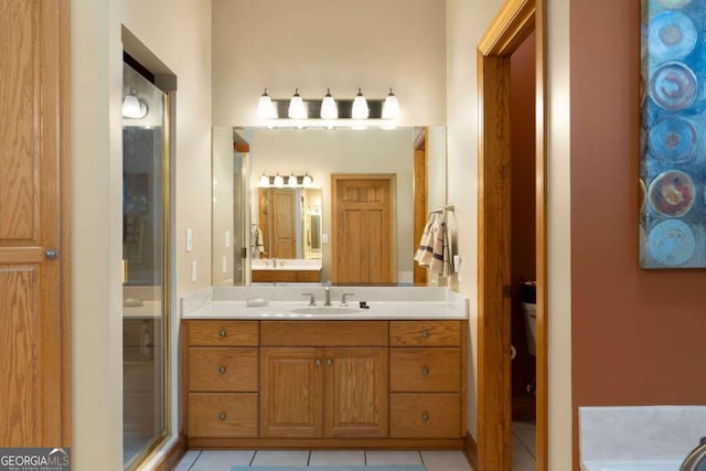 bathroom featuring tile patterned flooring, vanity, and a shower with door