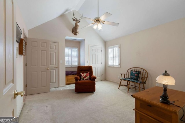 living area featuring light carpet, ceiling fan, and vaulted ceiling