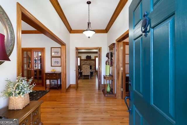 foyer with crown molding and light wood-type flooring