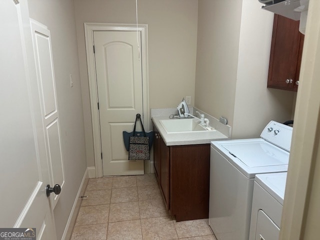 laundry room with cabinets, light tile patterned floors, sink, and washing machine and clothes dryer