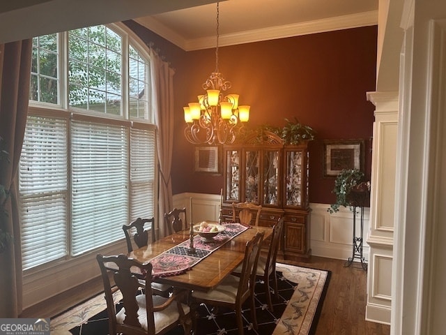 dining area featuring dark hardwood / wood-style flooring, crown molding, and a notable chandelier