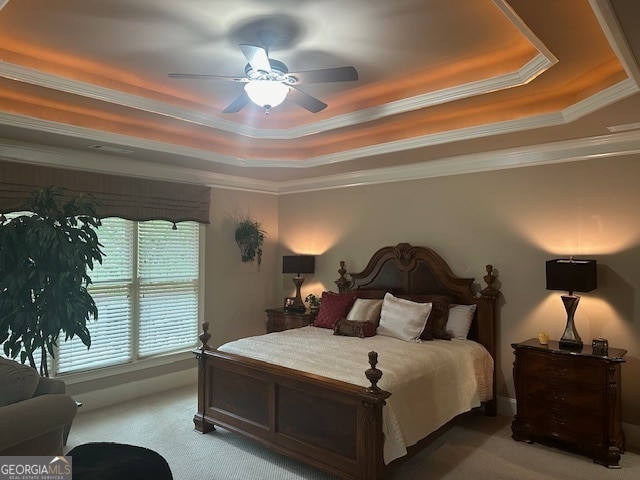 bedroom featuring carpet flooring, a tray ceiling, ceiling fan, and crown molding