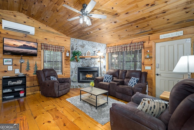 living room featuring lofted ceiling, wooden walls, a wall mounted air conditioner, light wood-type flooring, and wood ceiling