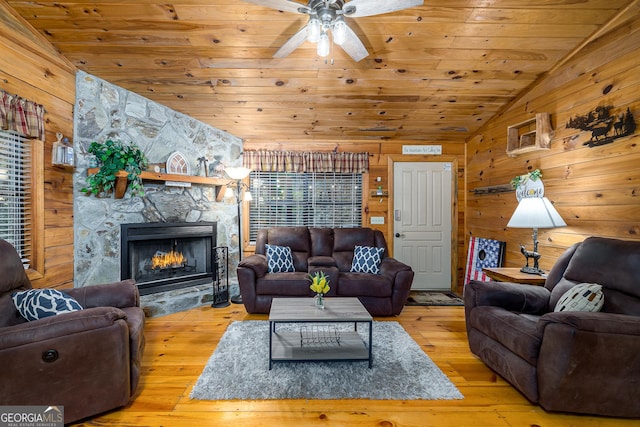 living room featuring vaulted ceiling, wood ceiling, wooden walls, and light wood-type flooring