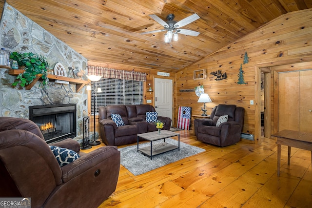 living room featuring hardwood / wood-style flooring, wooden walls, wooden ceiling, a fireplace, and vaulted ceiling