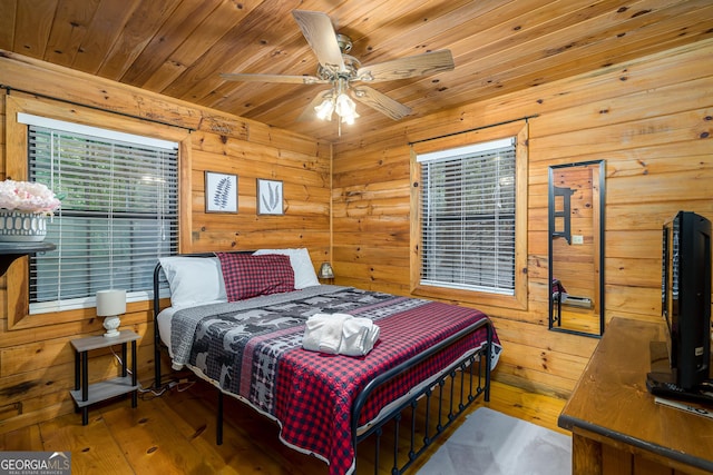 bedroom with ceiling fan, wood-type flooring, and wooden ceiling