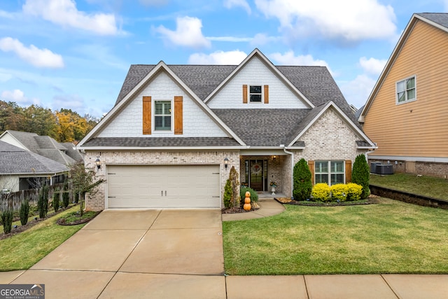 view of front of house featuring roof with shingles, brick siding, central AC unit, driveway, and a front lawn