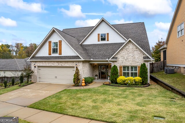 view of front of home featuring cooling unit, a garage, and a front lawn