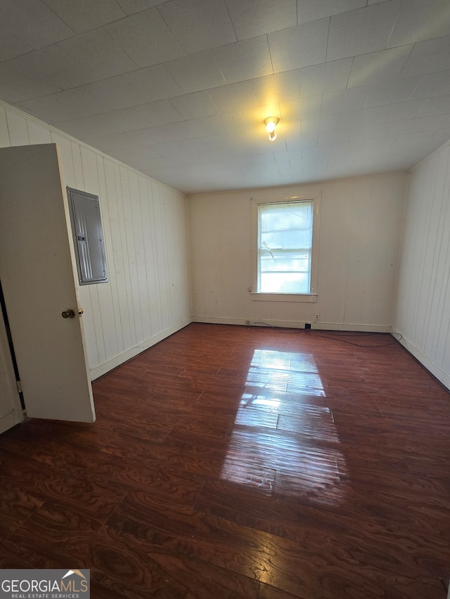 empty room featuring electric panel and dark hardwood / wood-style floors