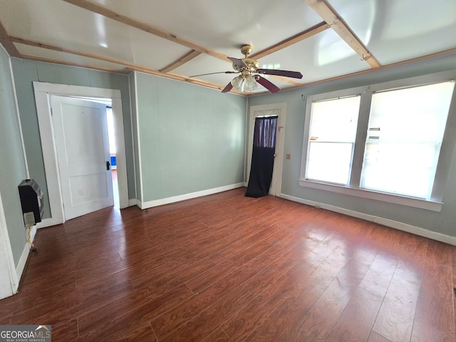 unfurnished room with dark hardwood / wood-style flooring, heating unit, and ceiling fan